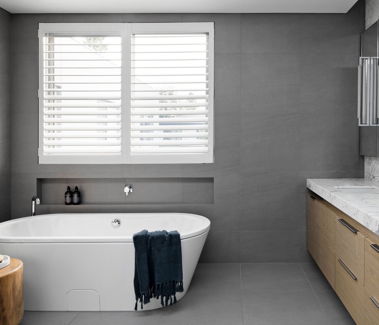 Plantation shutters behind a freestanding bath