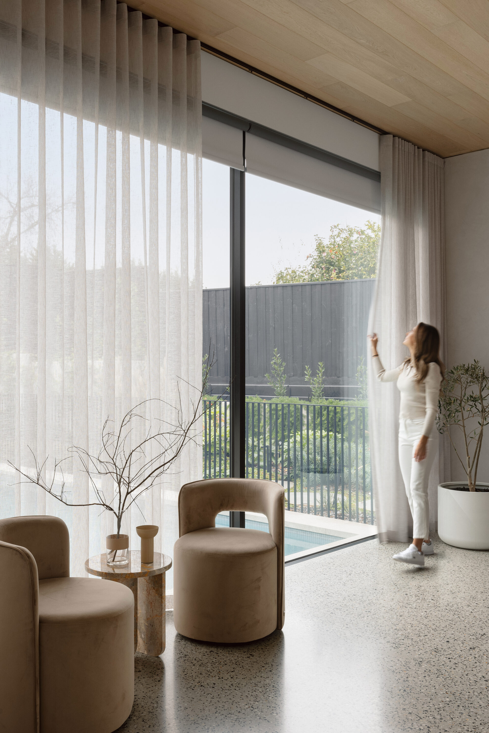 Sheer curtains layered with roller blinds in a Berwick home