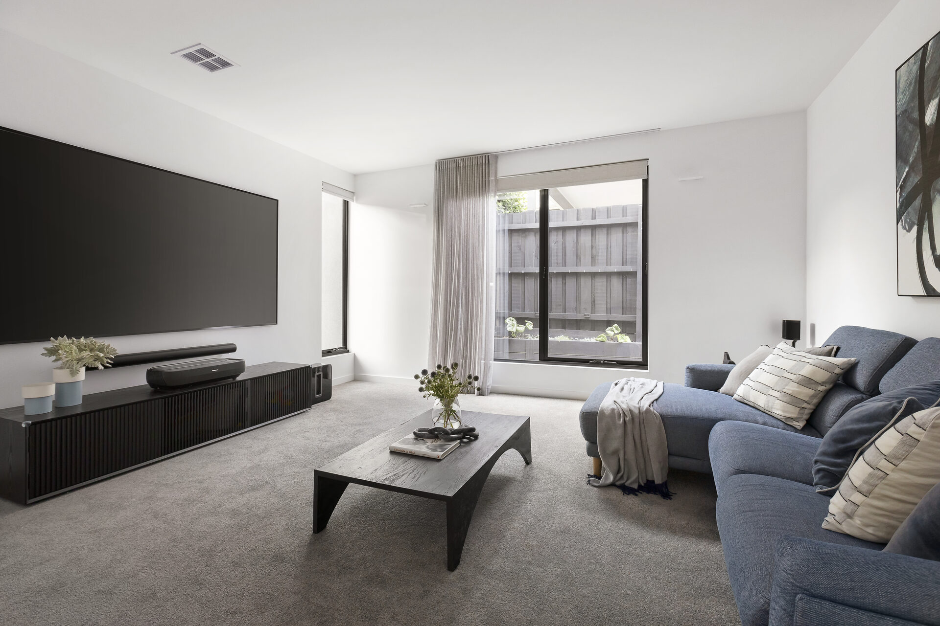 Layered roller blinds and sheer curtains in a contemporary living room