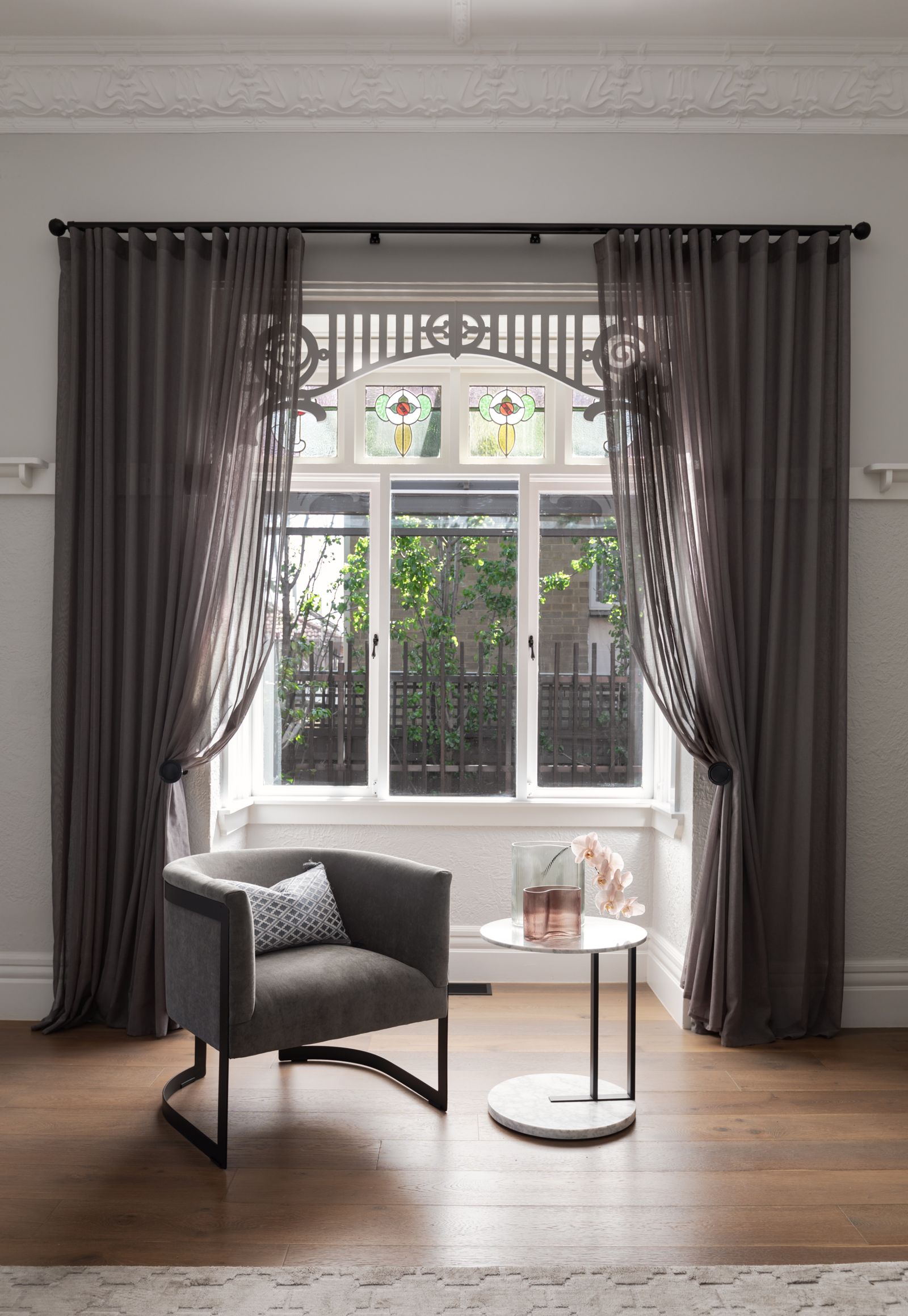 Asphalt sheer curtains on black decorative rods with traditional tiebacks