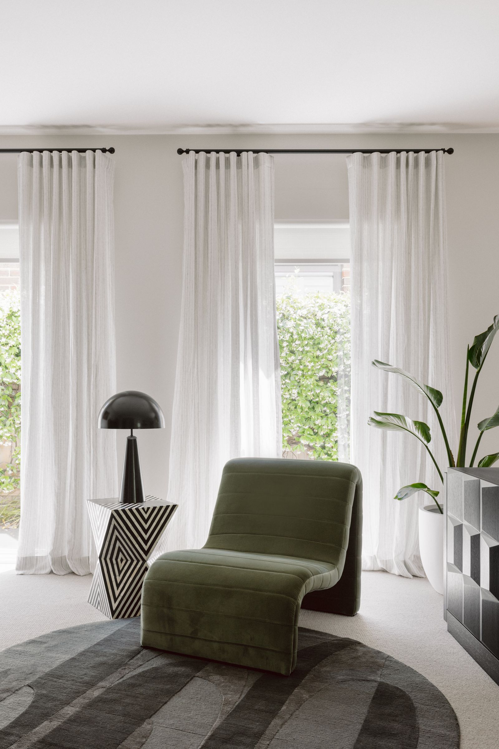 Cohesive grounded aesthetic with black hardware and linen sheers