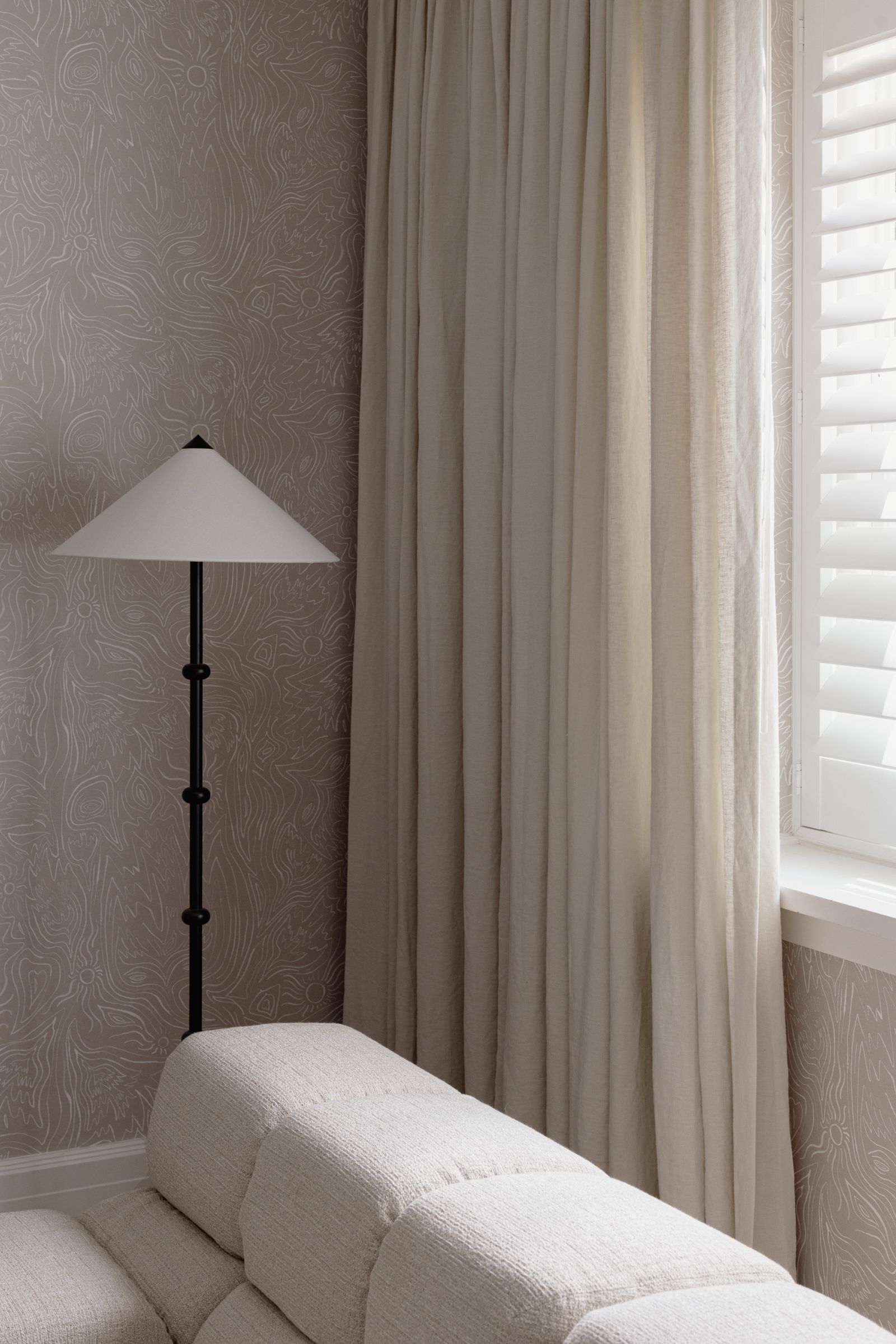 Structured shutters and soft curtains creating a layered window solution