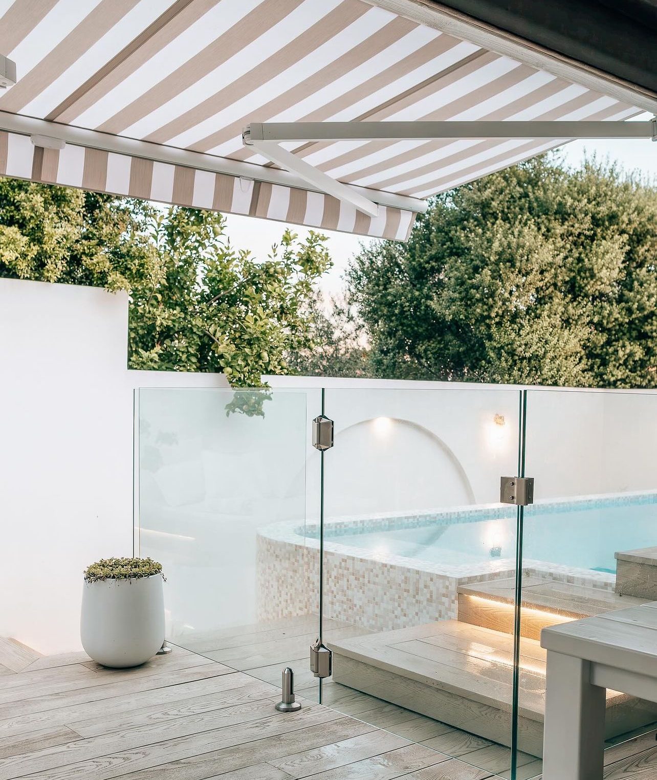 Folding arm awning shading a poolside courtyard in Melbourne