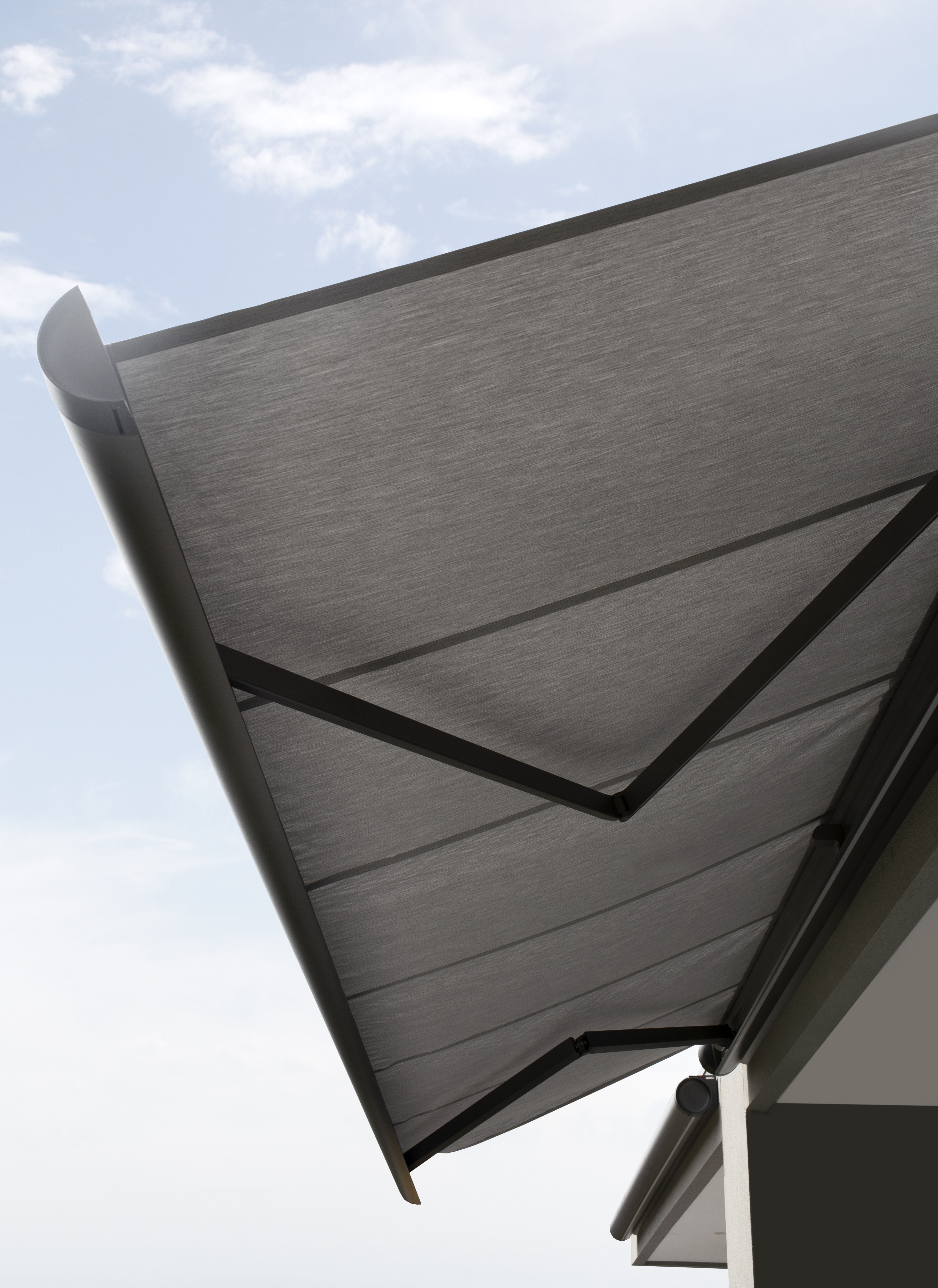 Folding arm awning fully extended over an alfresco area